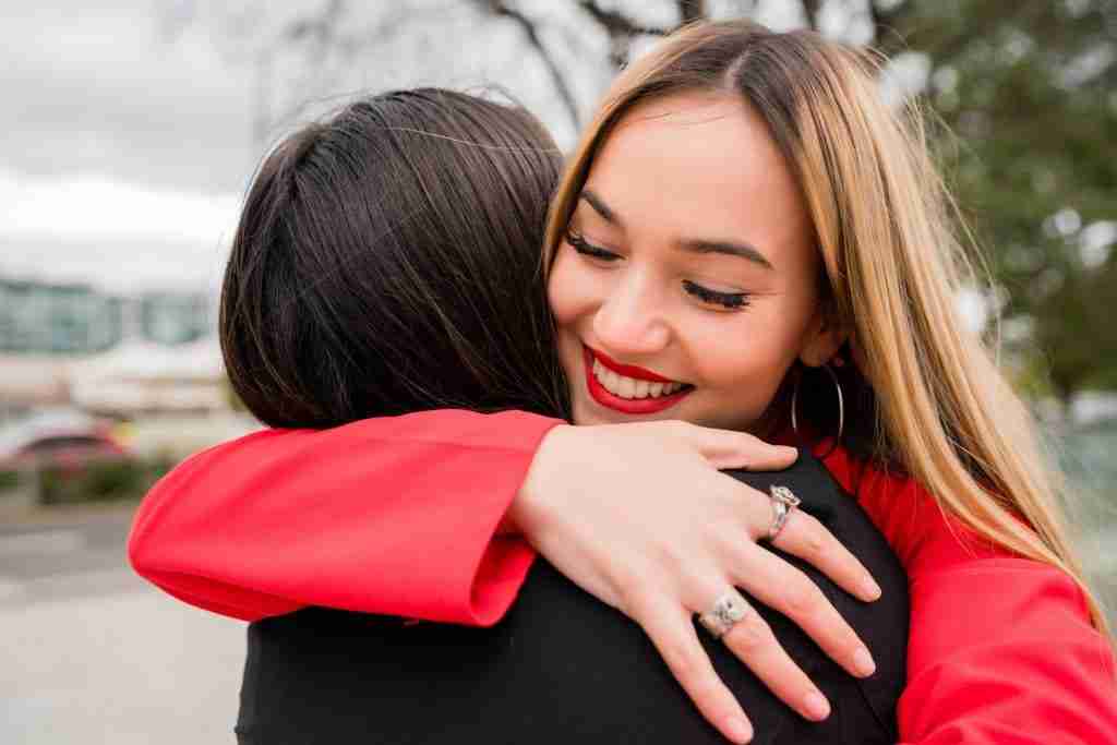 Two young friends hugging each other.