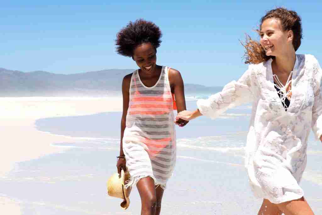 girls holding hands on beach