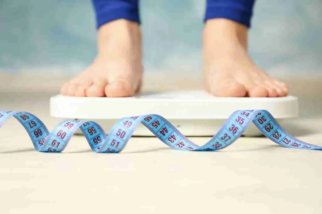 Woman stands on the scales. Measuring tape. Weight loss