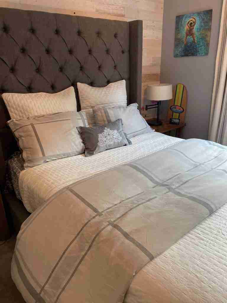 A boys bed layered with pillows and a  coverlet