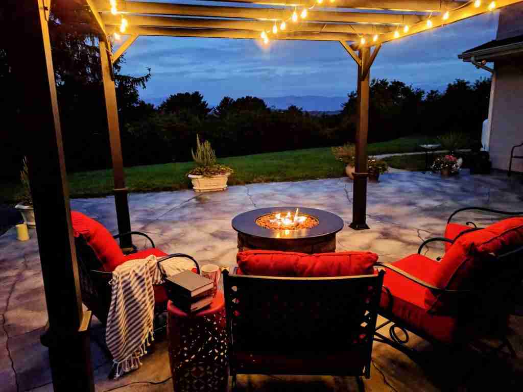 Outdoor living space with a gas fire pit in early morning on our back patio porch