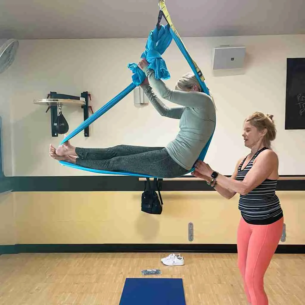 Aerial Yoga instructor helping a student in class