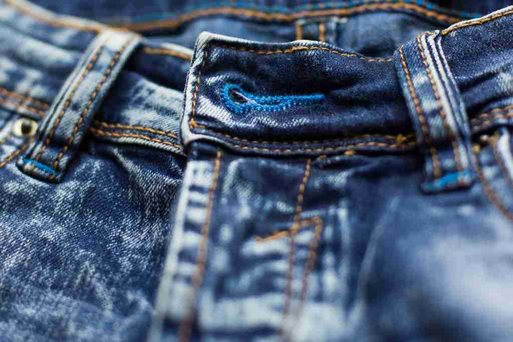 Denim texture. The background. Dark blue jeans. Jeans zipper. Pants fly close-up. Lock, clasp, butto