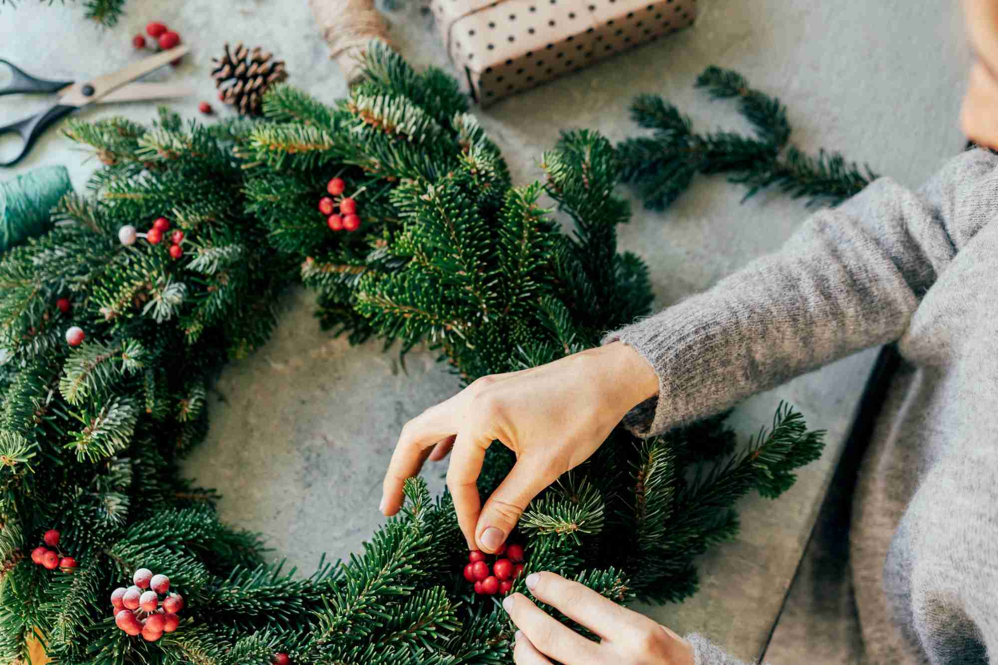 A woman is crafting a wreath for Christmas. Natural natural decoration
