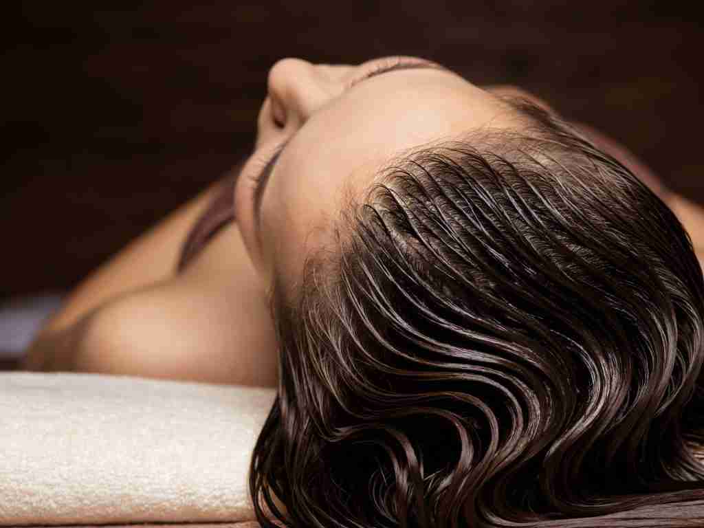 Woman receiving hair care procedure in spa salon