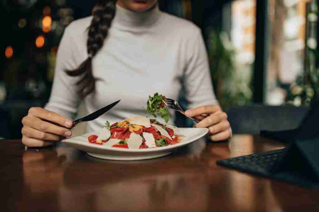 Using fork and knife, eating healthy.