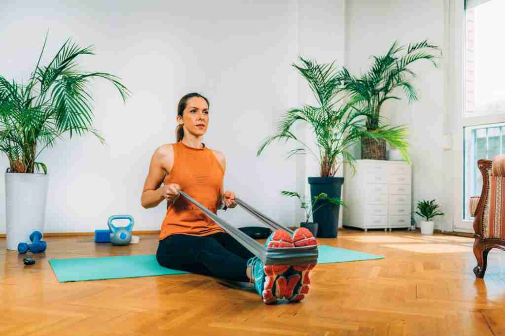 Woman Exercising with Elastic Band. Rowing Exercise Strength Training.