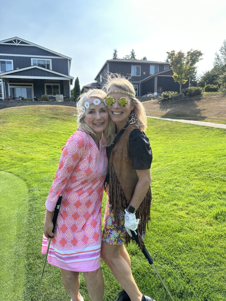 two girls on golf course wearing 60th costumes