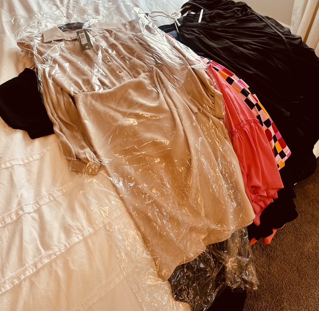 random clothes laying on a bed waiting to put in a organized closet- how to hang clothes 