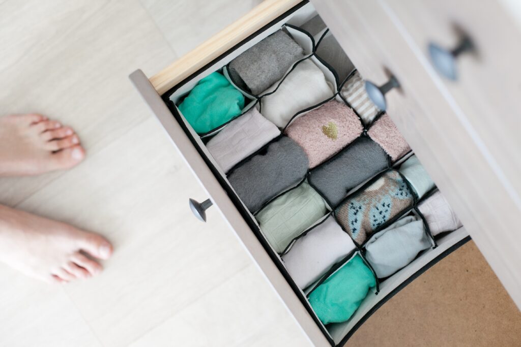 Organizing socks drawer and feet from above, high angle photo, chest of drawers, folding socks, tidy