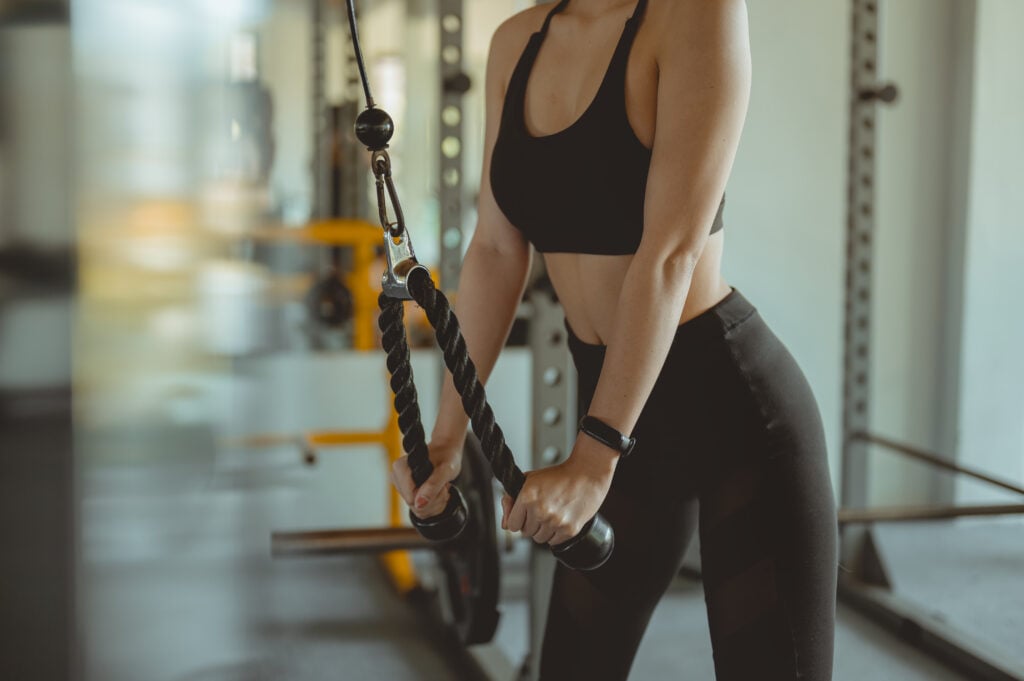 A women working out training arms in gym gaining weight pumping up muscles