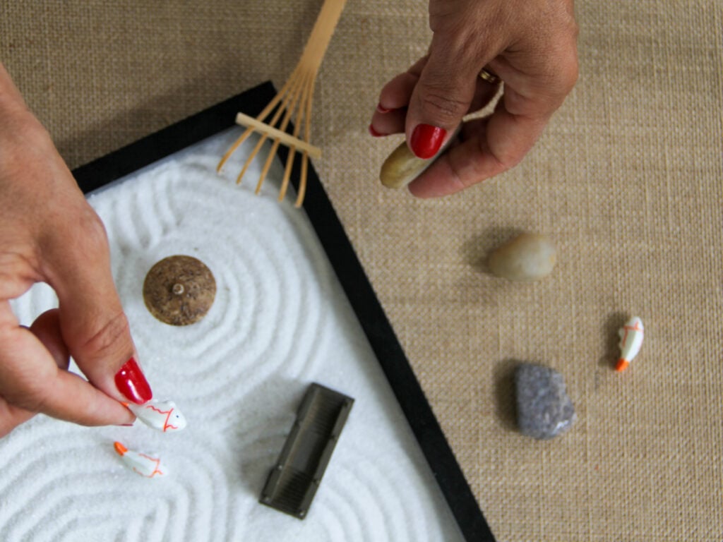 Overhead View of Woman Meditating with a Zen Garden Helping Her to Relax and Keep Her Mind Healthy.