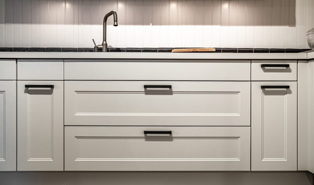 White kitchen cabinets with oil rubbed bronze pulls or knobs on the doors.