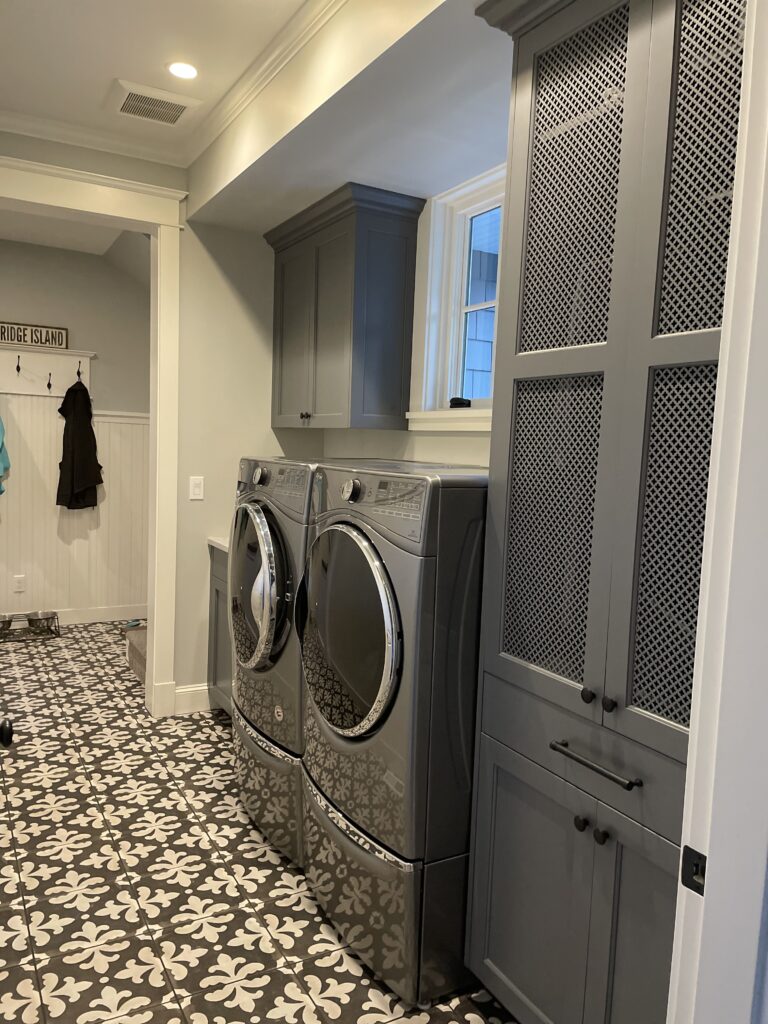Gray laundry room with gray and white tiled floors. 