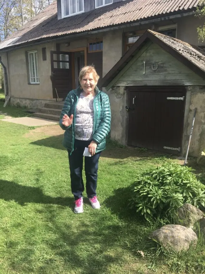 My 80 yr Mother standing in her childhood home's backyard. 