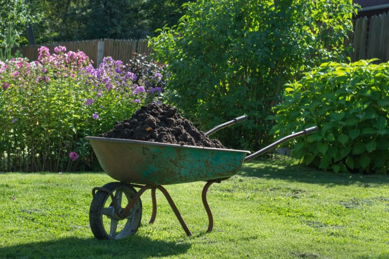 Garden-wheelbarrow filled with soil on a farm.