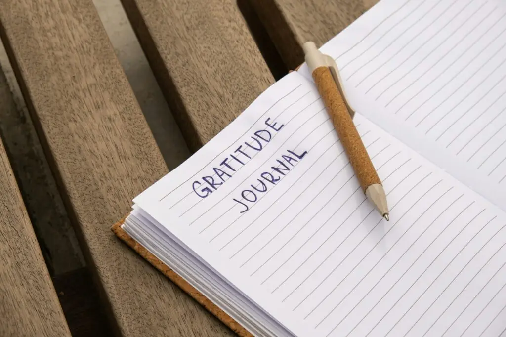 Writing Gratitude Journal on wooden bench. Today I am grateful for. Self discovery journal, self