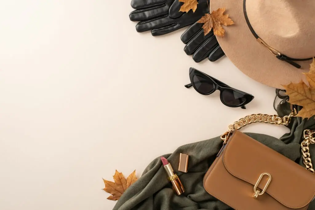 Fall-inspired outfit arrangement. Overhead shot of brimmed felt hat, gloves, trendy glasses