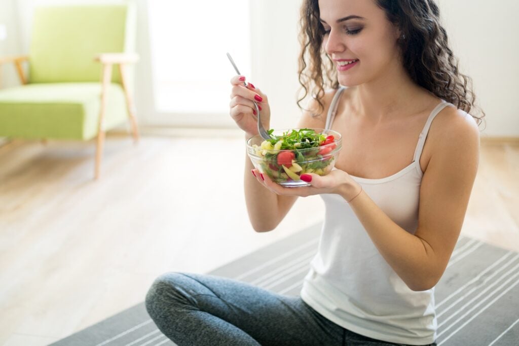 Fitness woman eating healthy food after workout