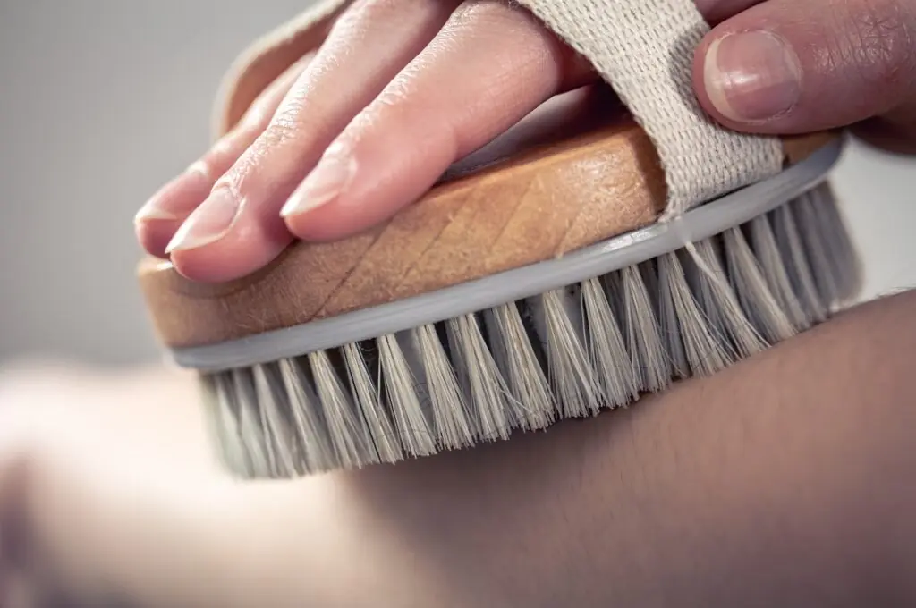 Female hands massage with a massage brush.