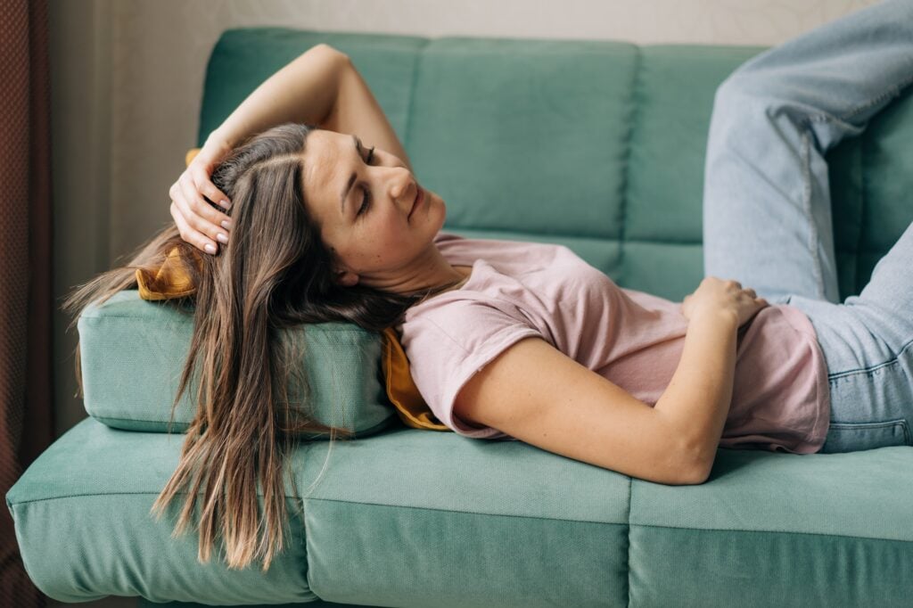 Relaxed woman lies on the sofa.